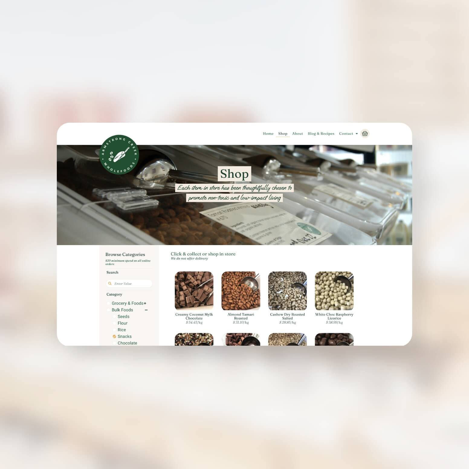 Armstrong Creek Wholefoods website over a blury background of the store